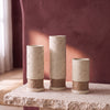 Rustic Column Trio: three ivory textured plaster candle holders with jute twine bands, 17, 20 and 12 cm, on a stone slab