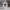 Abstract white vase on a marble table with a gray sofa and plant in the background