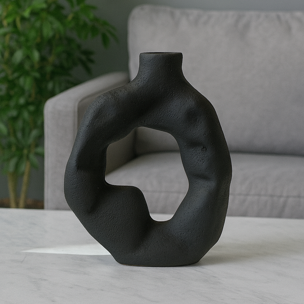 Black abstract vase on a table with a blurred background