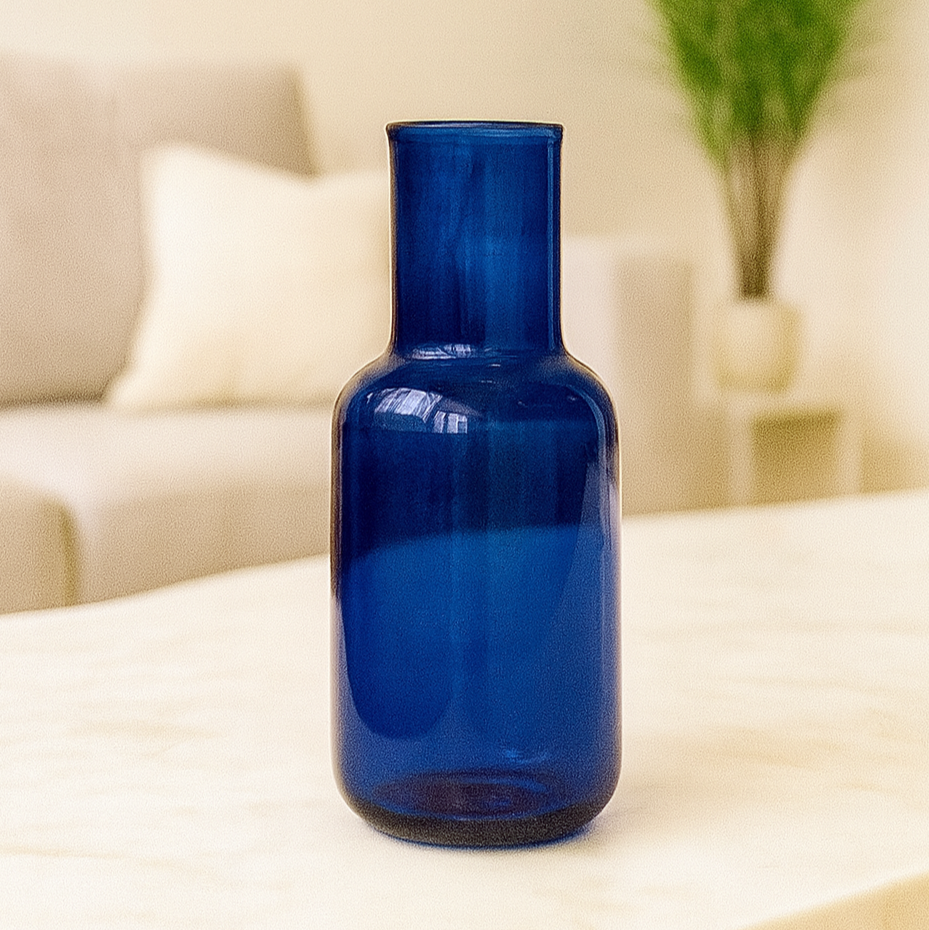 Blue glass bottle on a table with a blurred indoor background