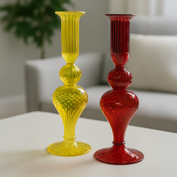 Yellow and red glass candle holders on a light surface with a blurred background