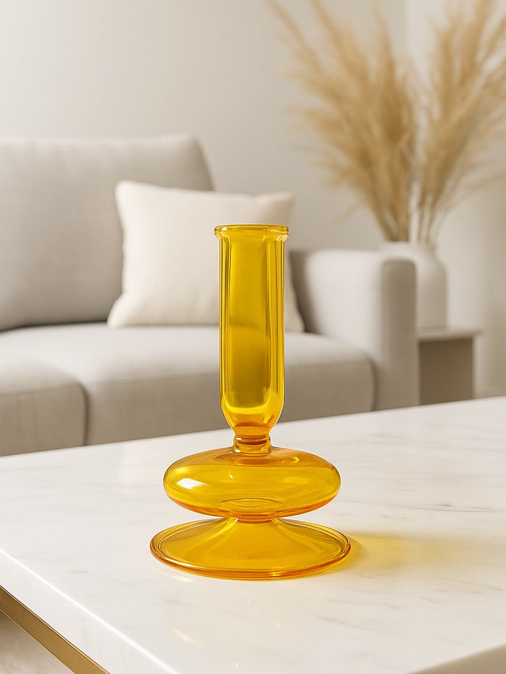 Yellow glass candle holder on a white surface with a blurred background